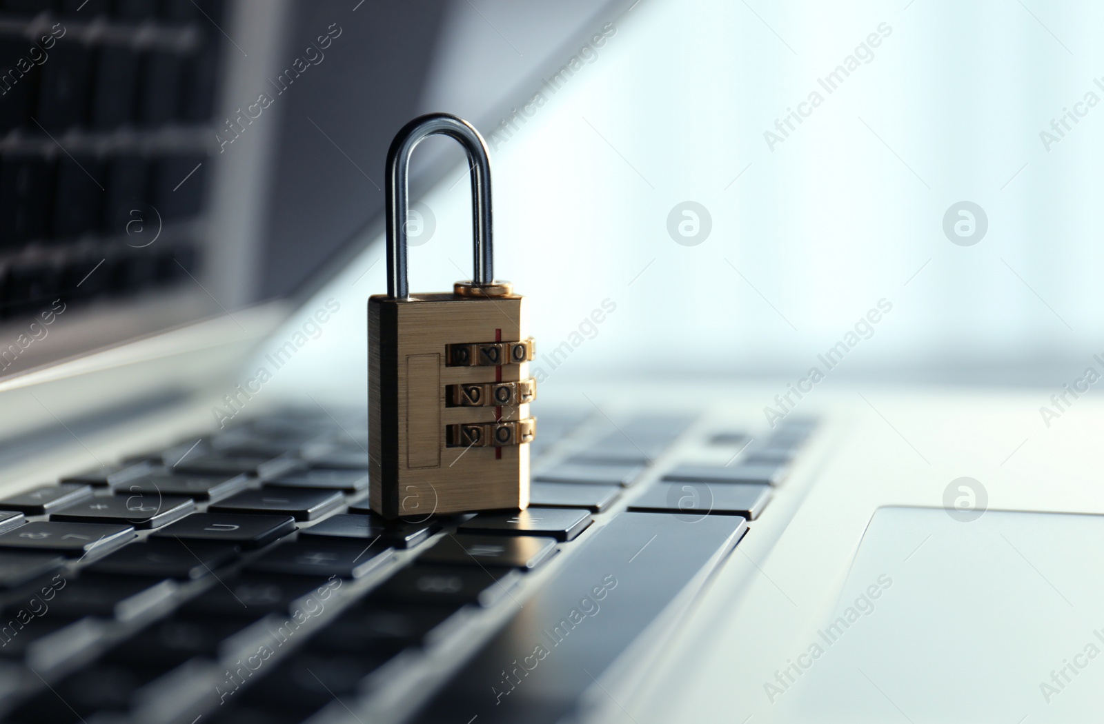 Photo of Metal code padlock on laptop keyboard, space for text. Cyber security concept