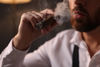 Photo of Bearded man smoking cigar indoors, closeup view