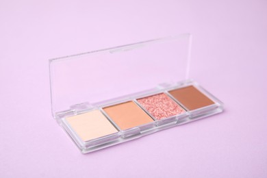 Photo of Beautiful eye shadow palette on lilac background