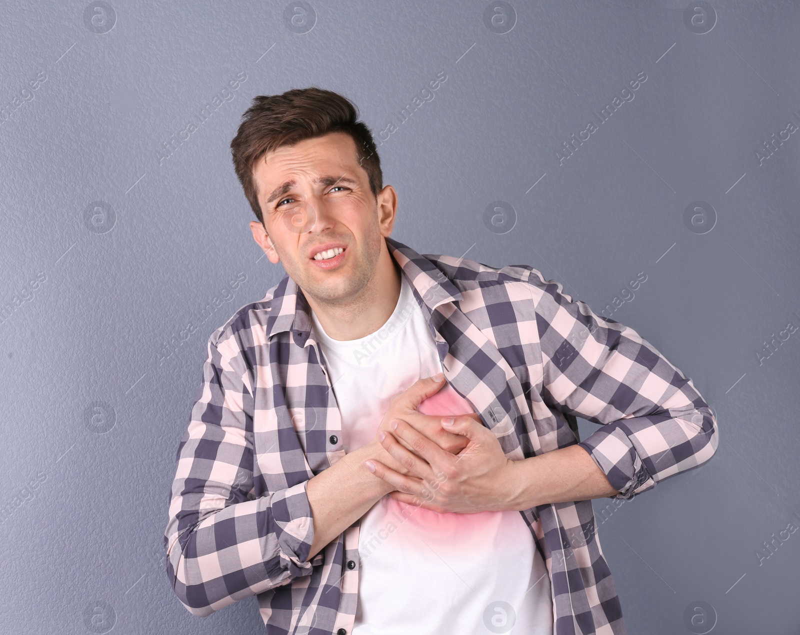 Photo of Young man having heart attack on color background