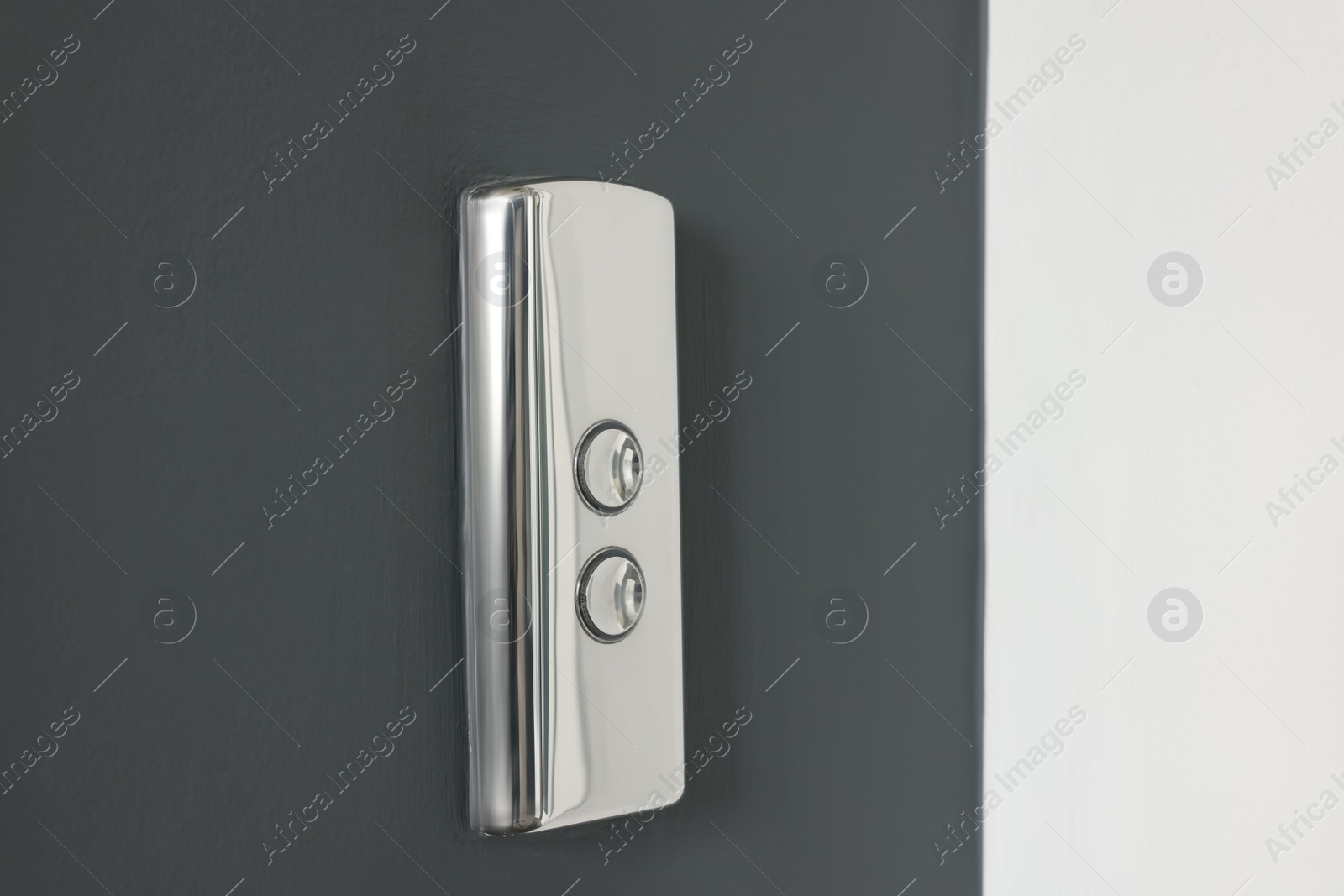 Photo of Elevator call buttons on grey wall, closeup