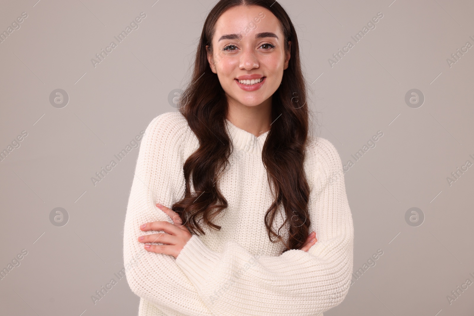 Photo of Beautiful young woman in stylish warm sweater on grey background