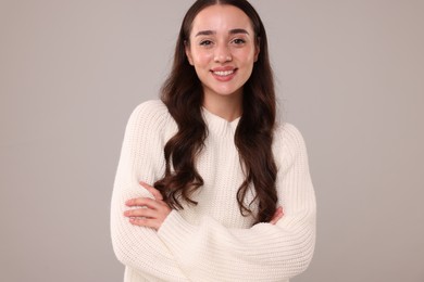 Photo of Beautiful young woman in stylish warm sweater on grey background