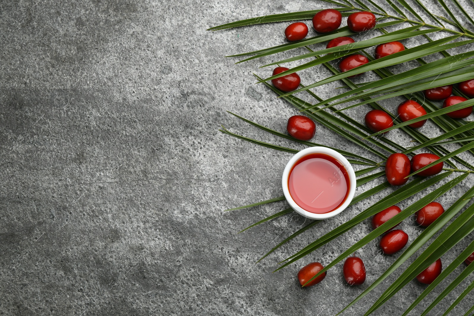 Photo of Flat lay composition with palm oil and fresh fruits on grey table. Space for text