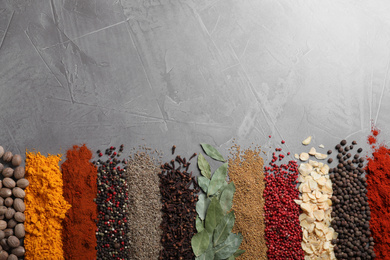 Different spices on grey background, top view. Space for text