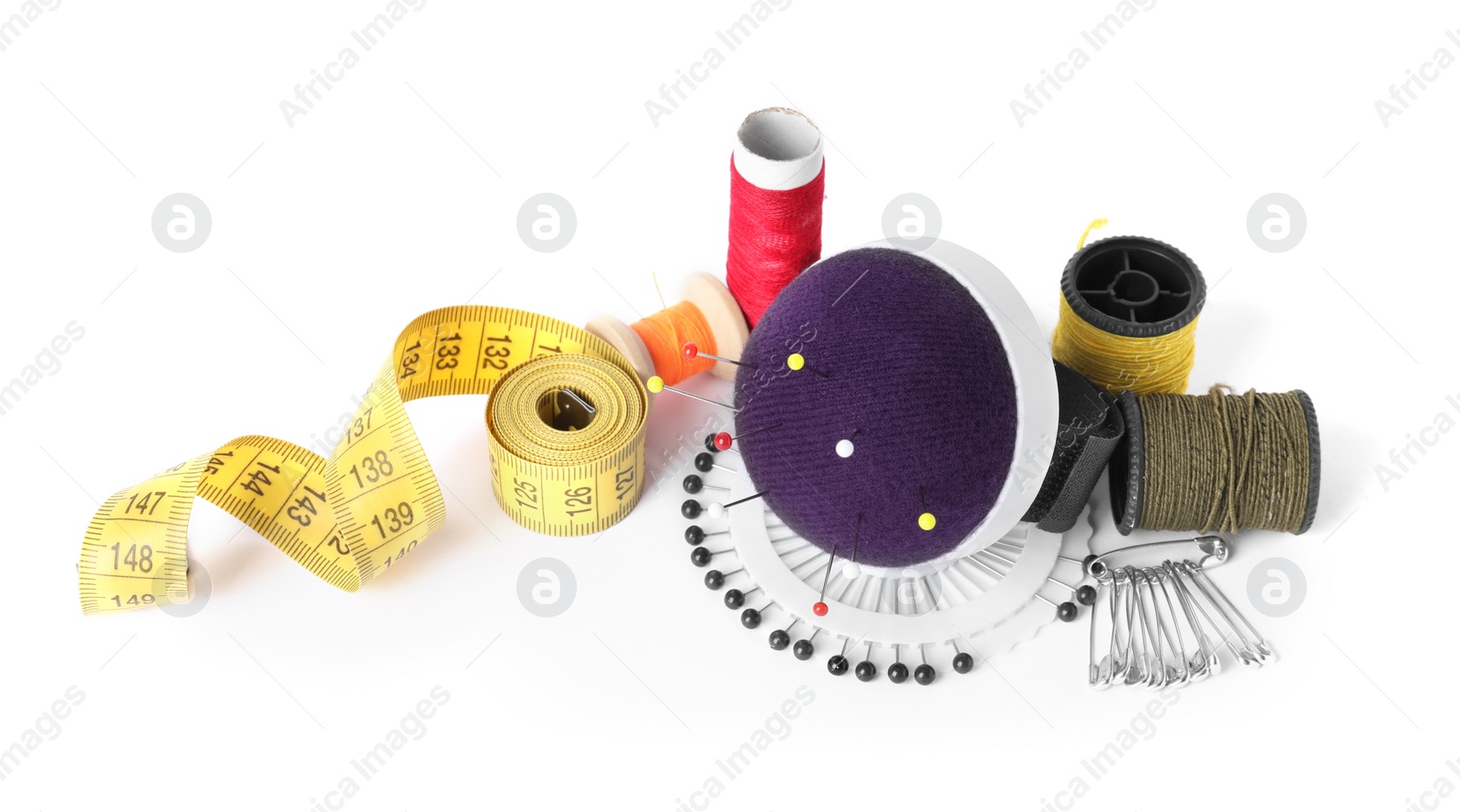 Photo of Pincushion, pins and other sewing tools isolated on white