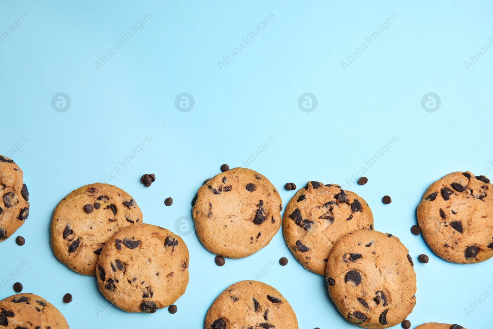 Photo of Delicious chocolate chip cookies on color background, flat lay. Space for text