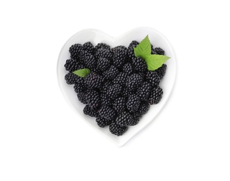 Photo of Heart shaped bowl of tasty blackberries with leaves on white background, top view