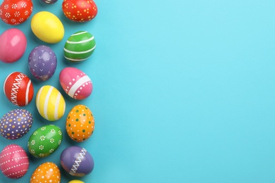 Decorated Easter eggs and space for text on color background, top view