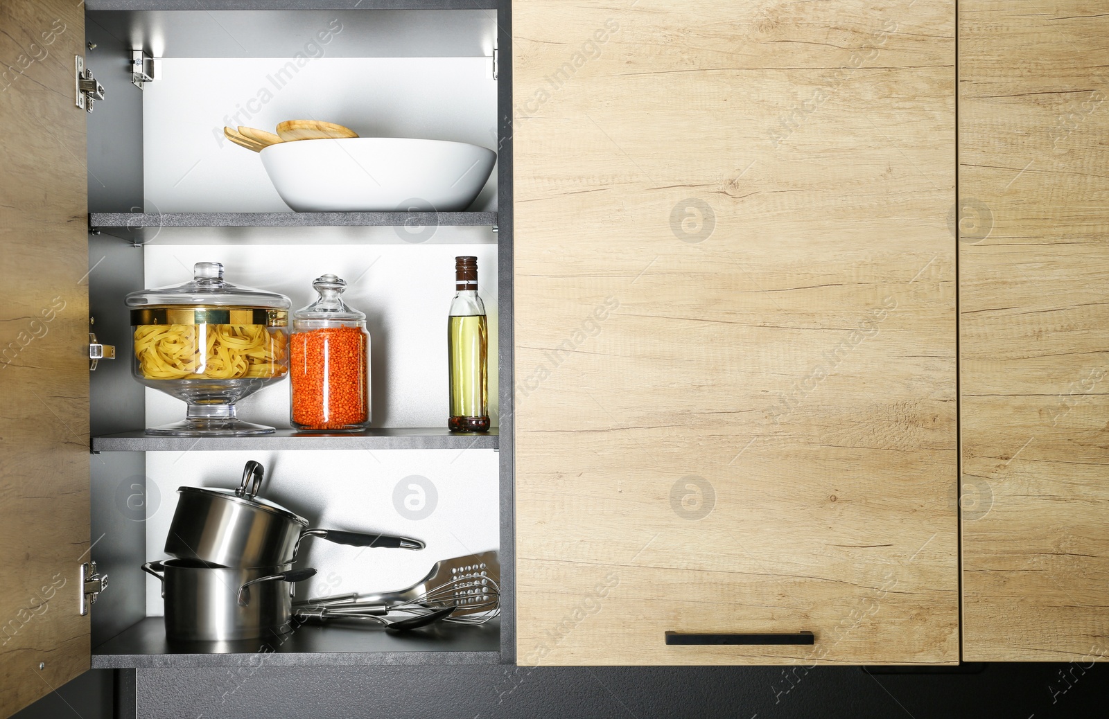 Photo of Products and kitchen utensils on modern shelving unit