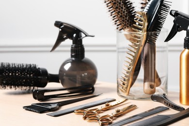 Photo of Hairdresser tools. Different scissors and combs on wooden table in salon