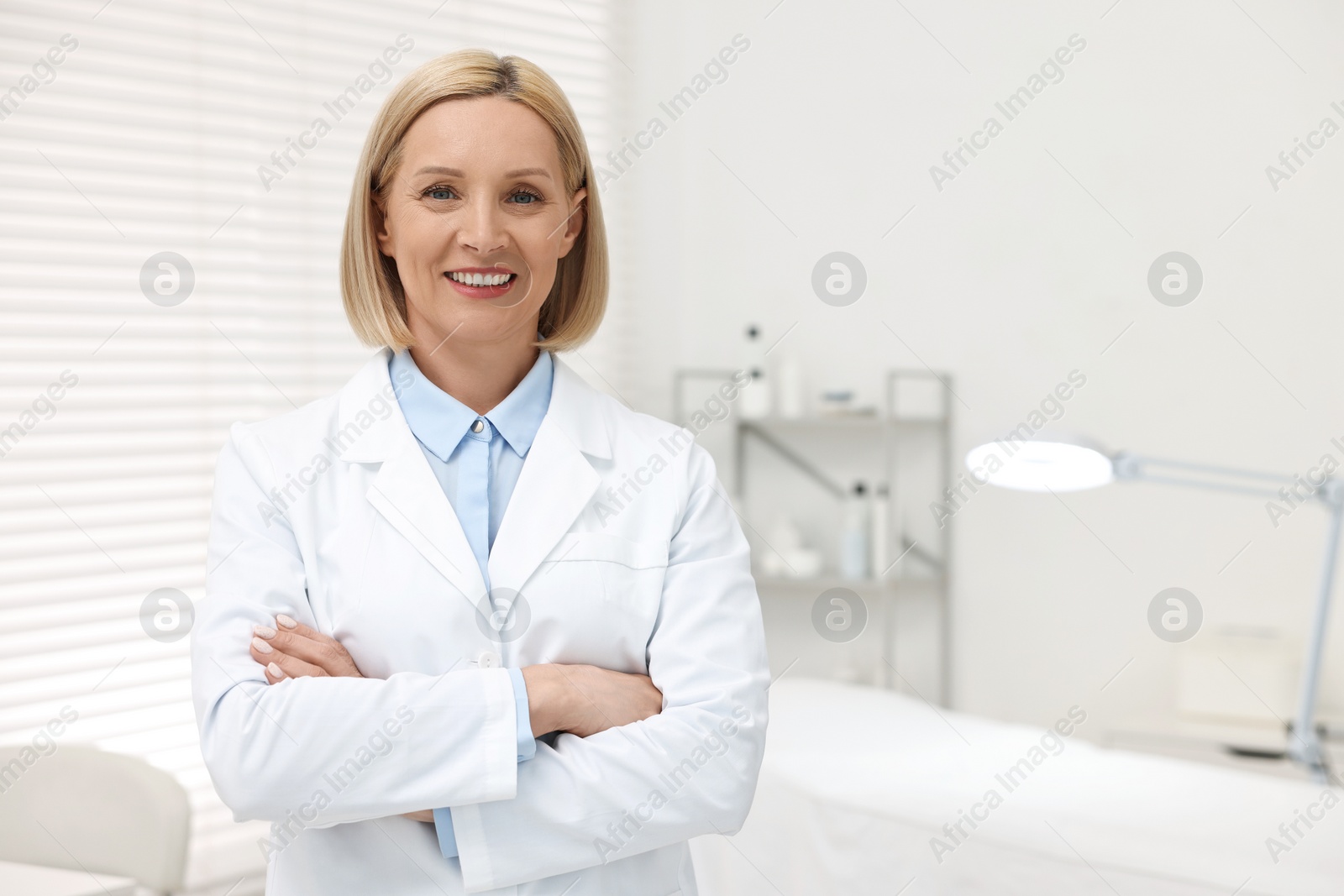 Photo of Portrait of happy dermatologist in modern clinic, space for text