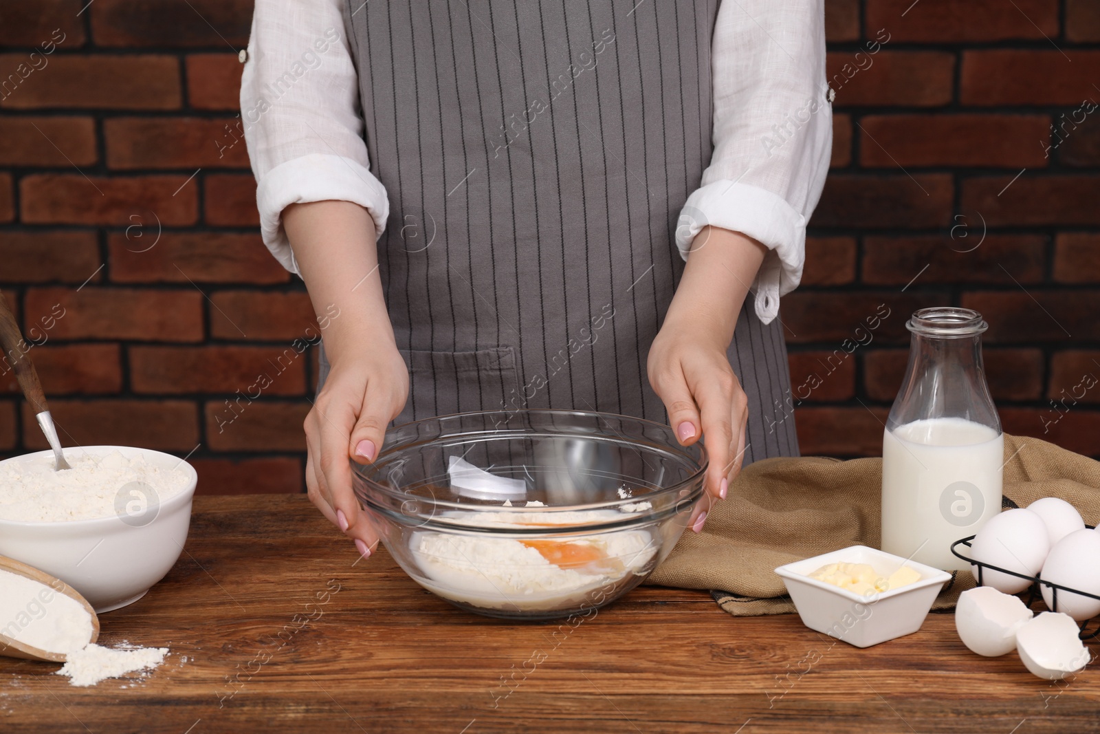 Photo of Making tasty baklava. Woman with ingredients for dough at wooden table, closeup