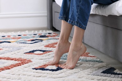 Photo of Woman on carpet with pattern at home, closeup. Space for text