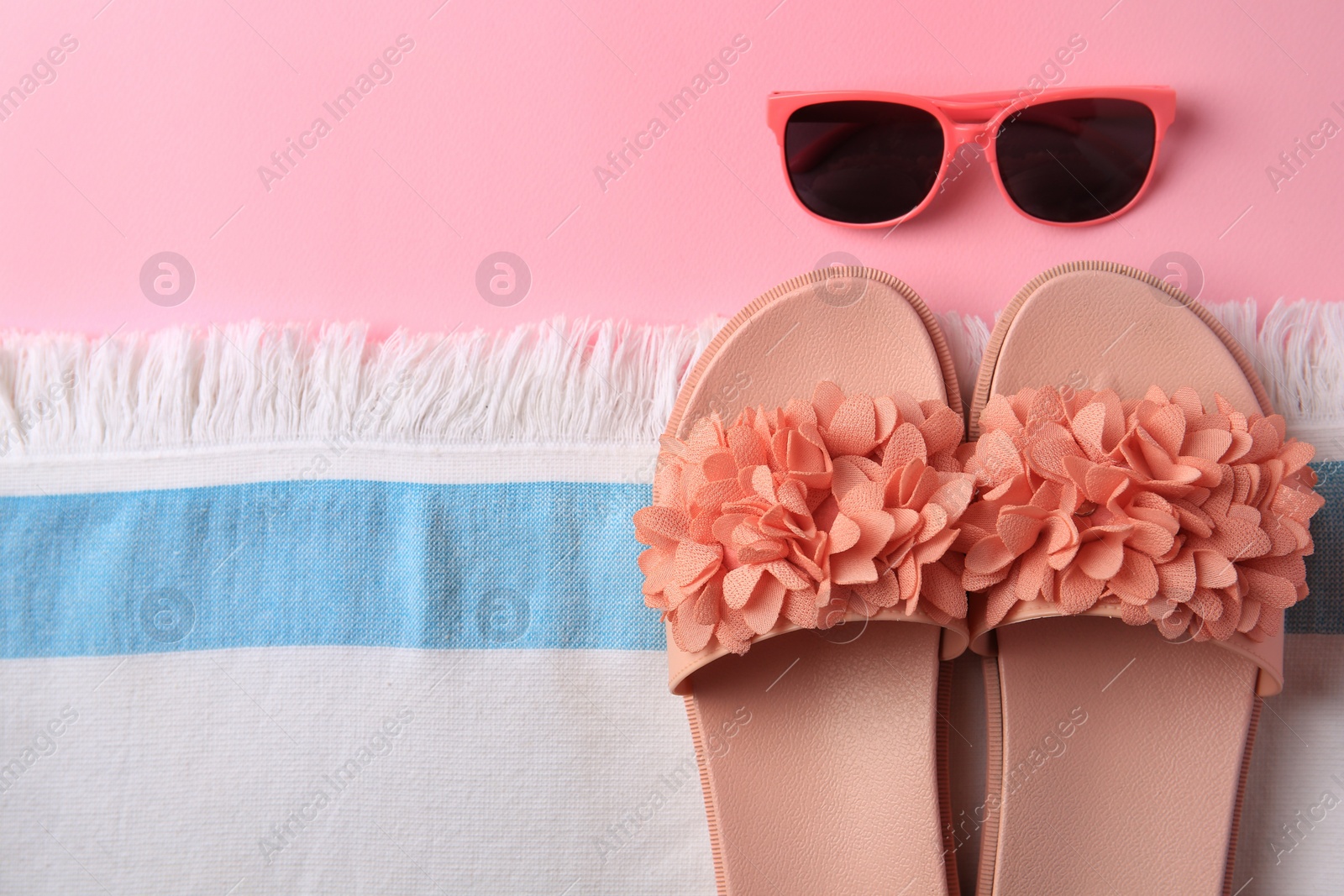 Photo of Flat lay composition with beach accessories on pink background