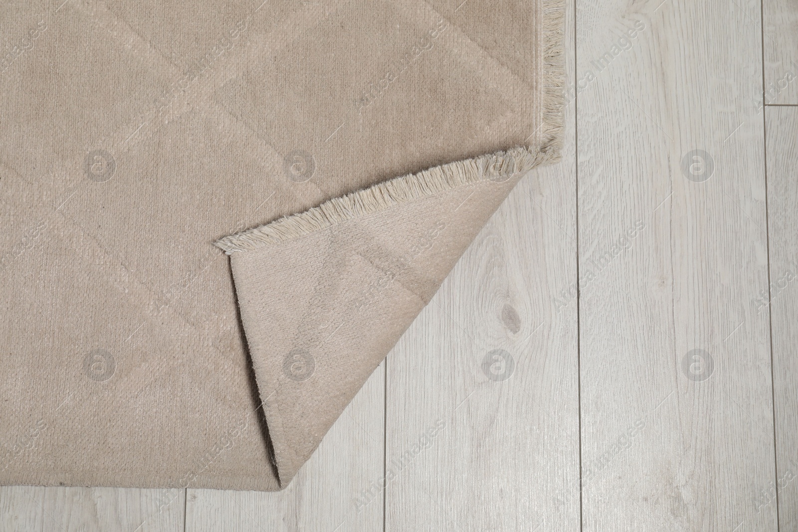 Photo of Soft beige carpet on white laminated floor indoors, top view. Space for text