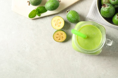 Photo of Fresh feijoa smoothie and fresh fruits on light table, flat lay. Space for text