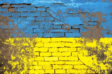 Image of National flag of Ukraine painted on old brick wall