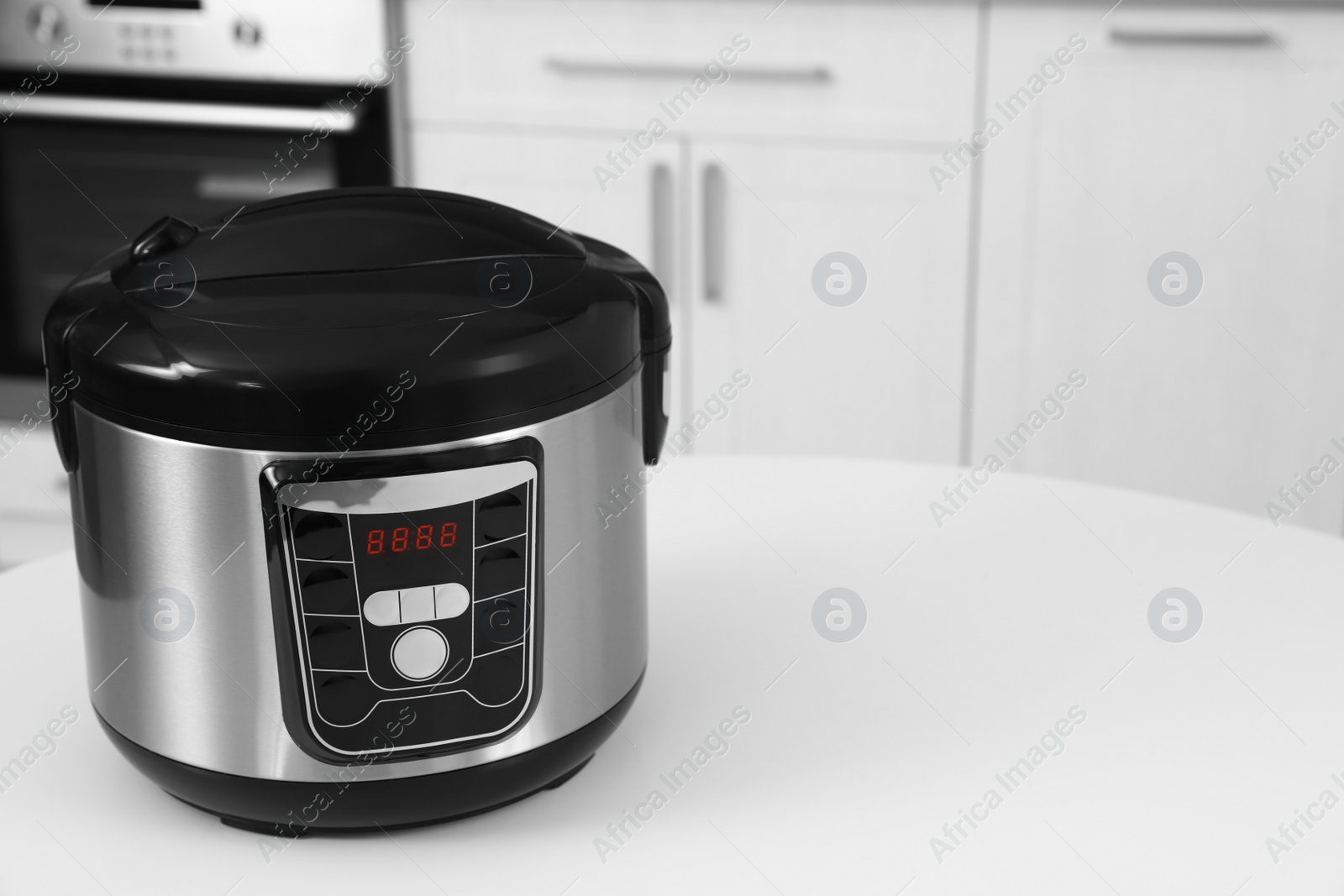 Photo of New modern multi cooker on table in kitchen. Space for text