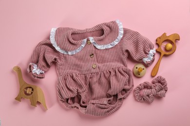 Photo of Flat lay composition with baby clothes and accessories pink background