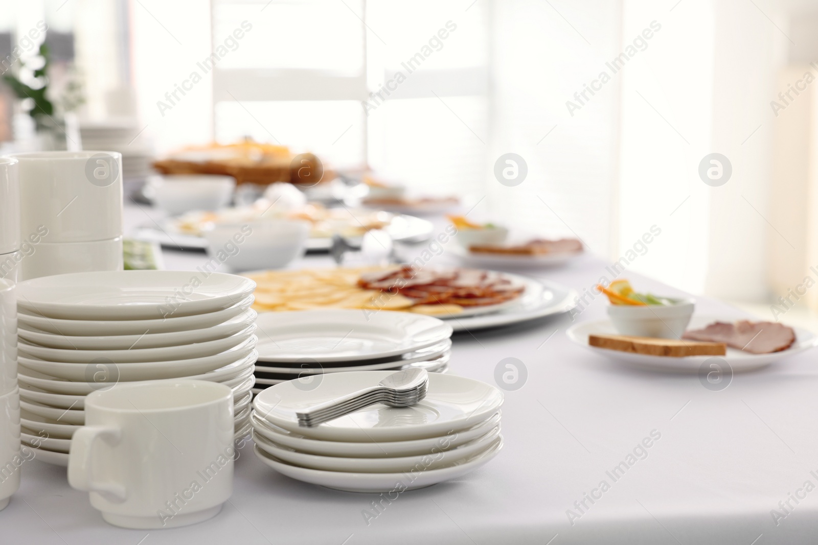 Photo of Clean dishware and different meals for breakfast on white table indoors. Buffet service