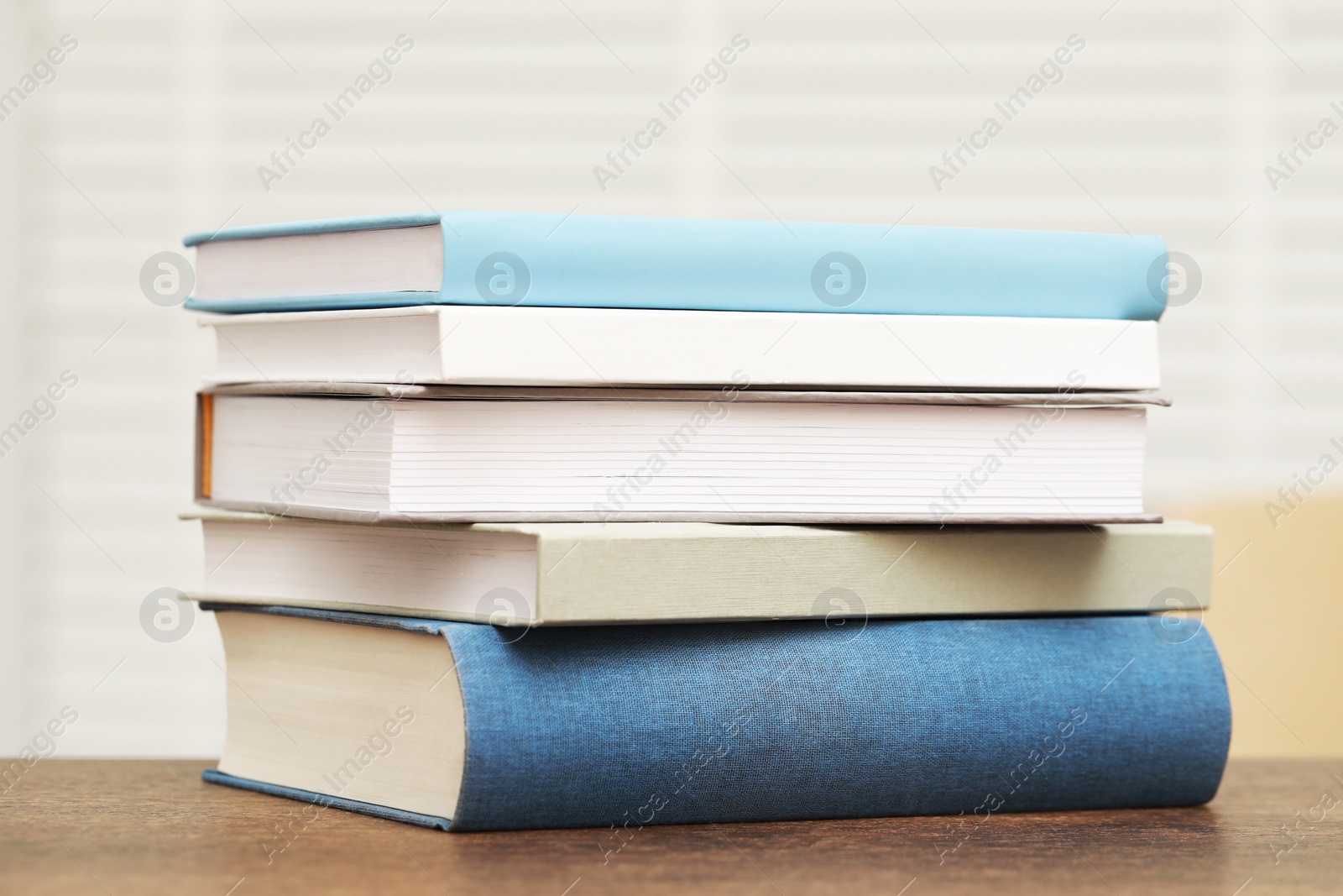 Photo of Stack of hardcover books on wooden table indoors