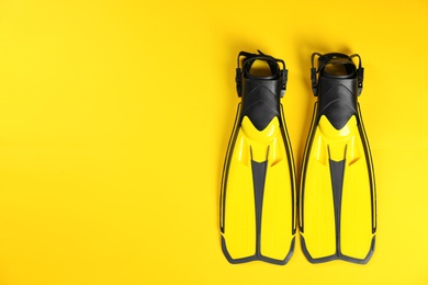 Photo of Swimming flippers on color background, top view. Space for text
