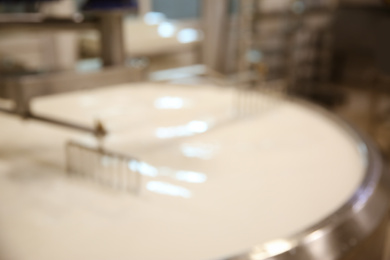 Blurred view of curd preparation tank with milk at cheese factory