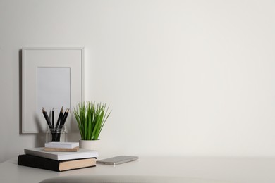 Comfortable workplace with white desk near wall at home