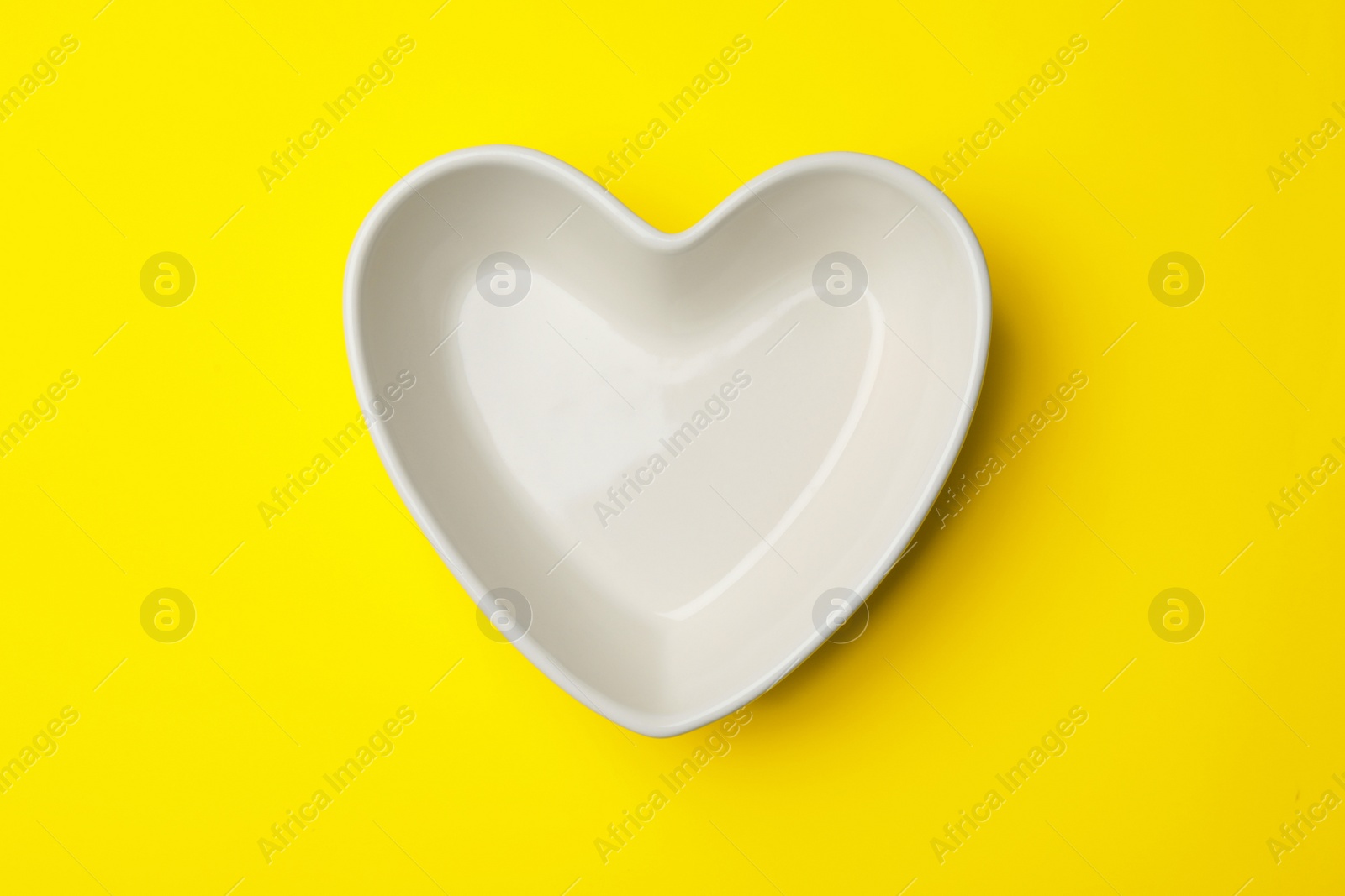 Photo of Heart shaped plate on color background, top view