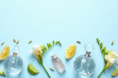 Photo of Flat lay composition with elegant perfumes on light blue background, space for text