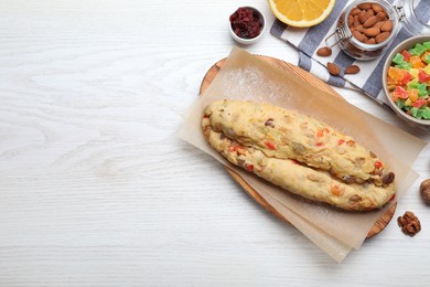 Photo of Unbaked Stollen with candied fruits and raisins on white wooden table, flat lay. Space for text
