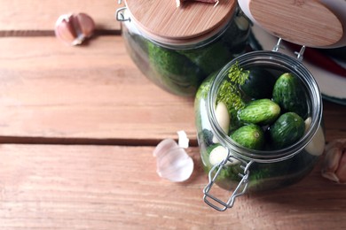 Photo of Jar with cucumbers, garlic and dill on wooden table, space for text. Pickling recipe