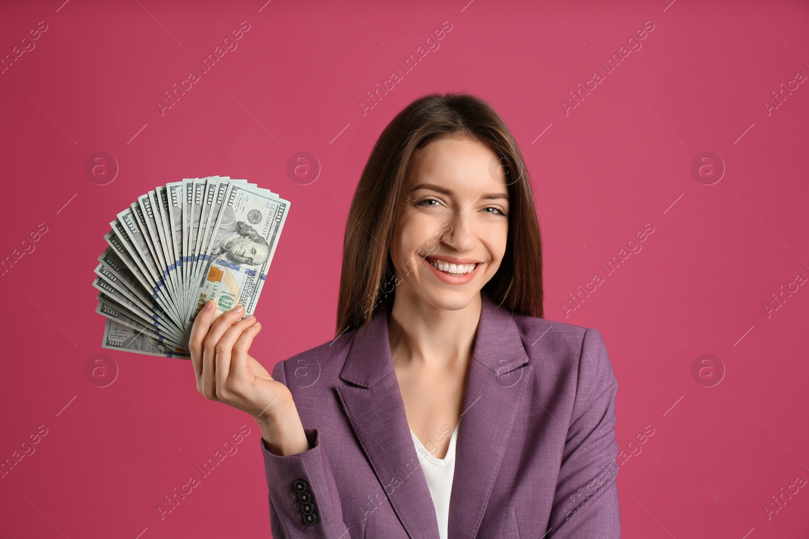 Photo of Happy young woman with cash money on pink background