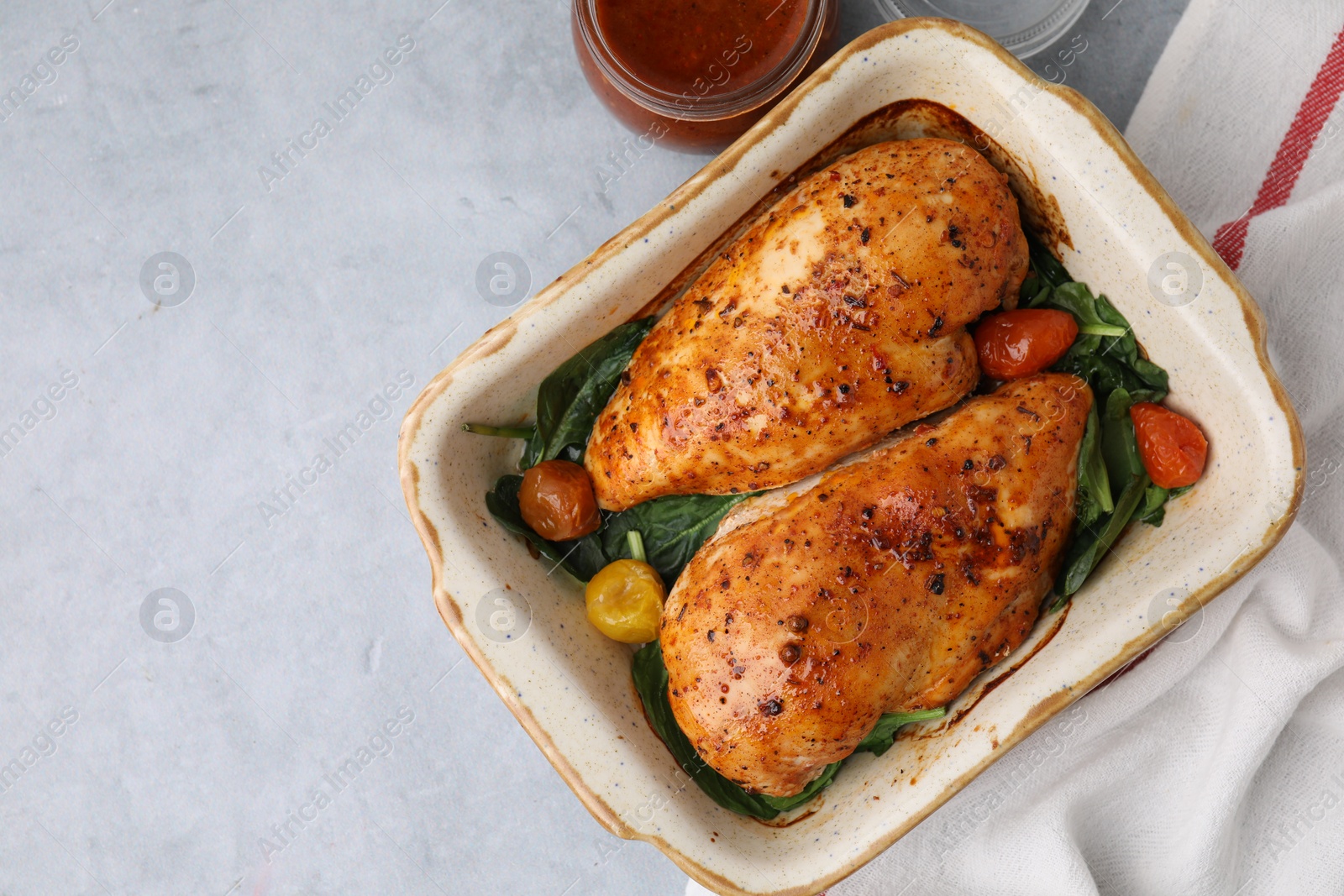 Photo of Baked chicken fillets with vegetables and marinade on grey table, top view