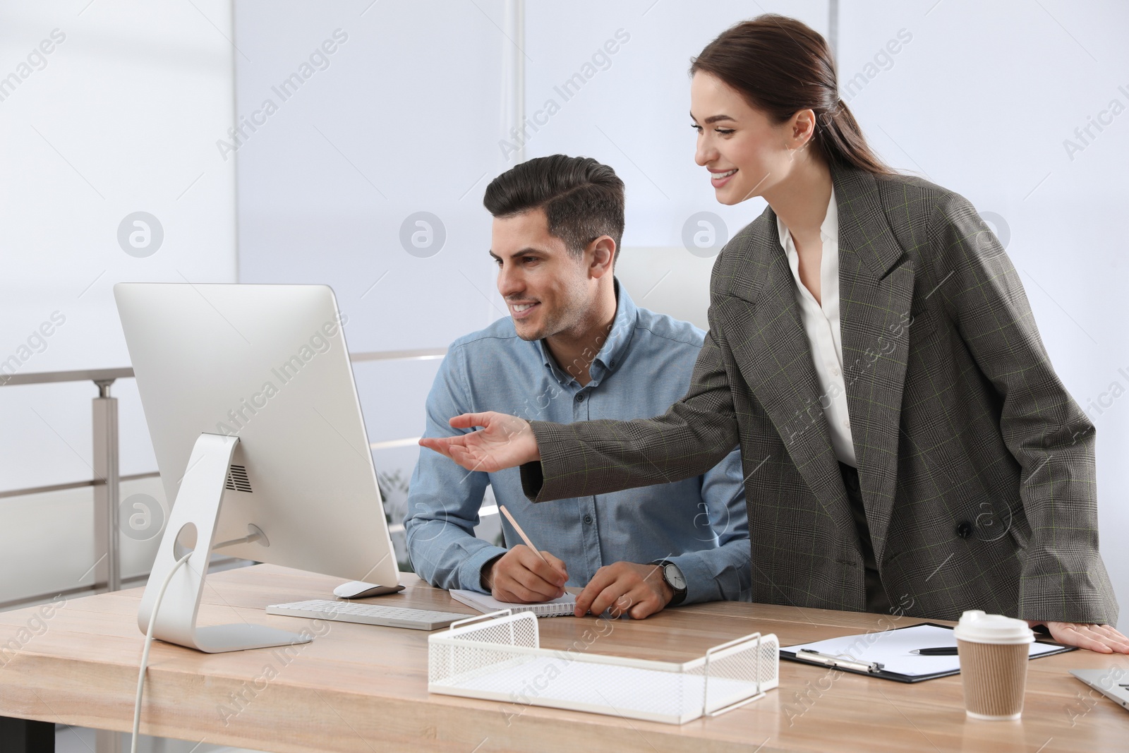 Photo of Businesswoman helping intern with work in office