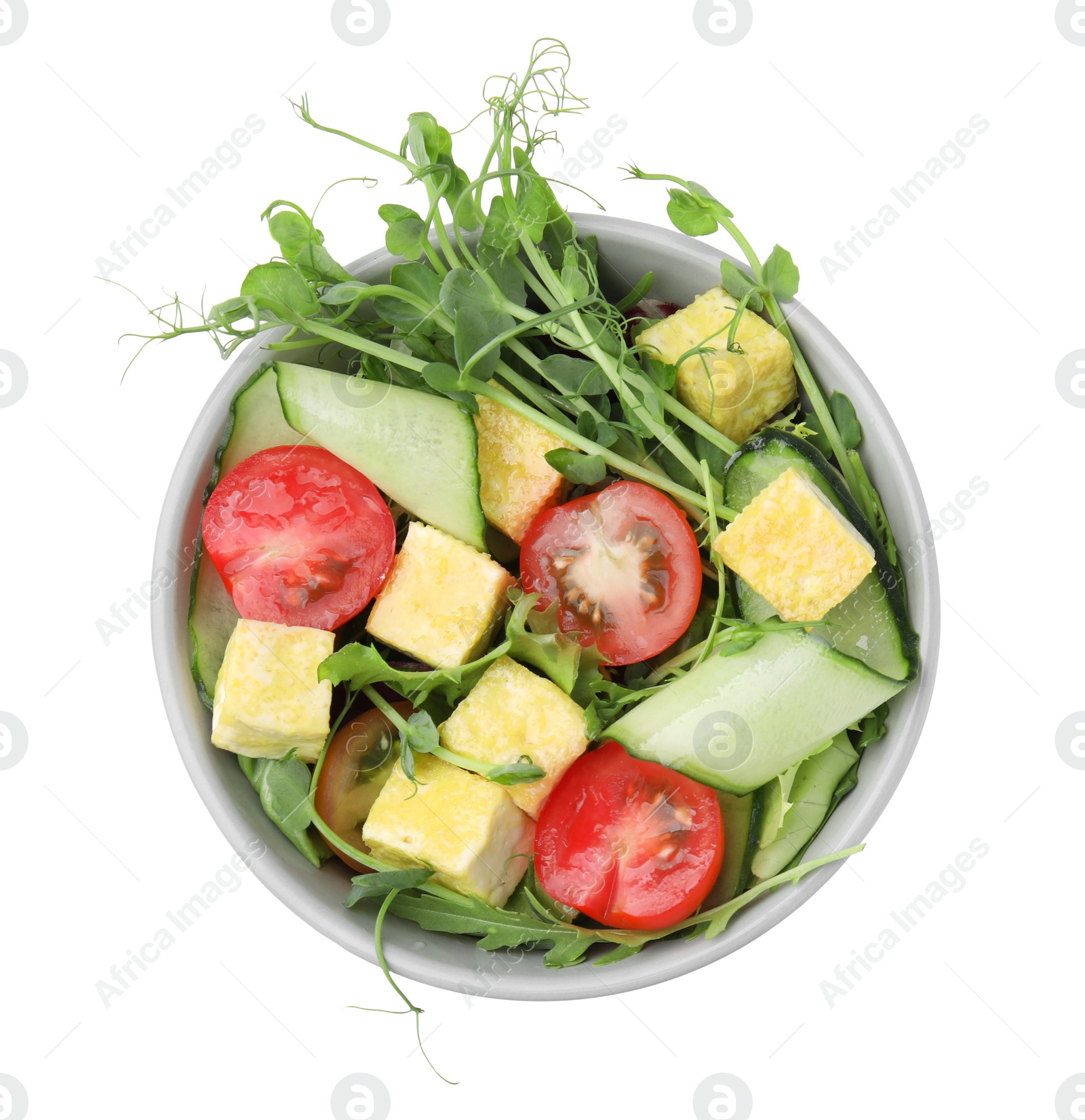 Photo of Bowl of tasty salad with tofu and vegetables isolated on white, top view