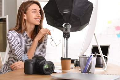 Photo of Professional photographer working at table in office