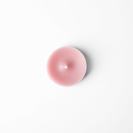 Photo of Pink wax decorative candle isolated on white, top view