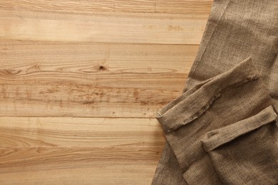 Burlap fabric on wooden table, top view. Space for text