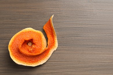 Photo of Dry orange peel on wooden table, top view. Space for text