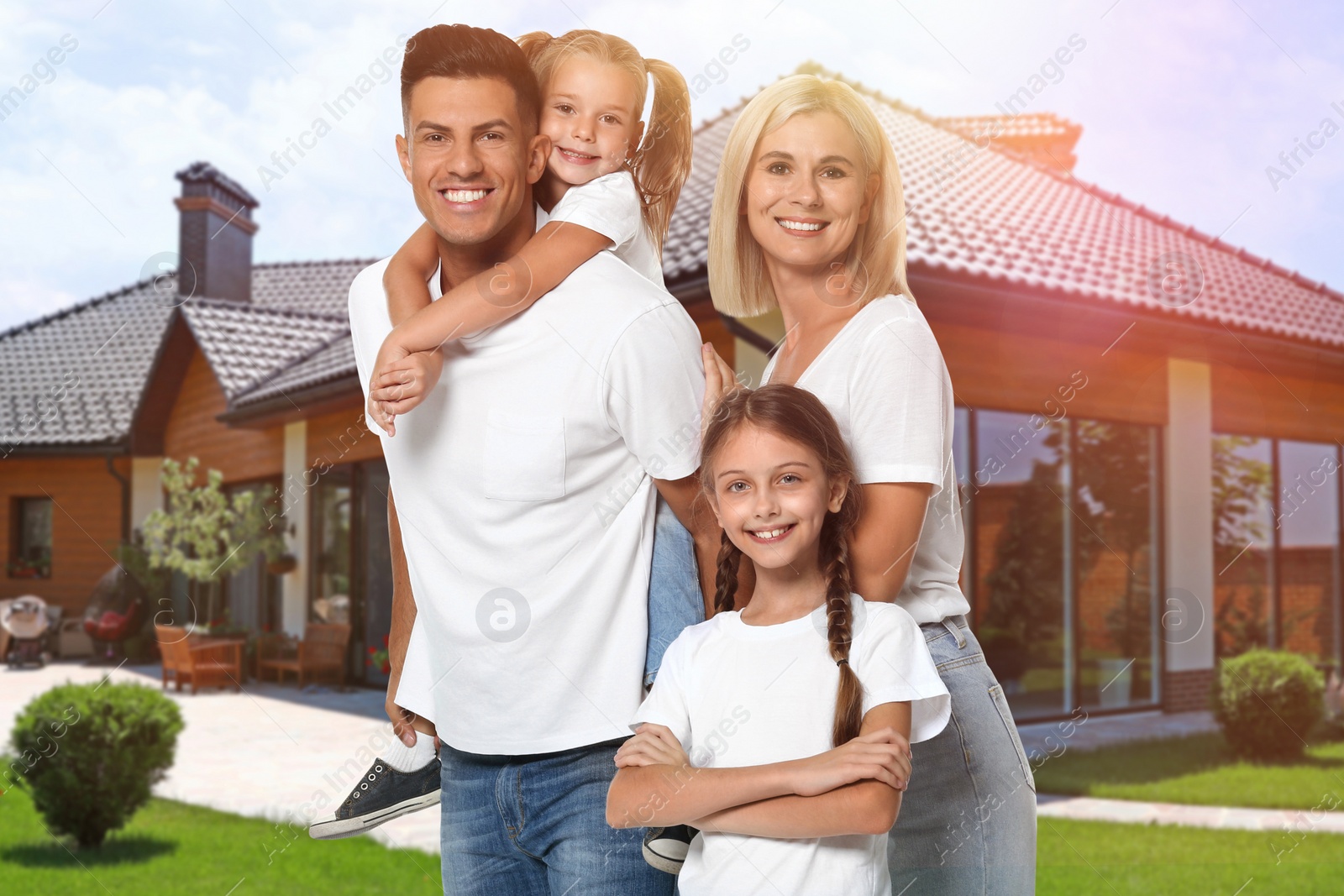 Image of Happy family standing in front of their house on sunny day 