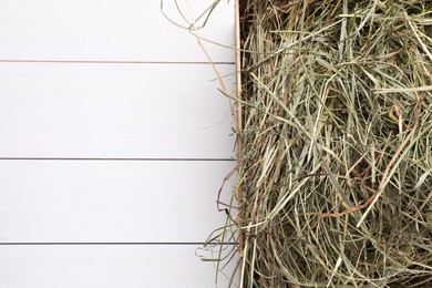 Photo of Heap of dried hay on white wooden table, top view. Space for text