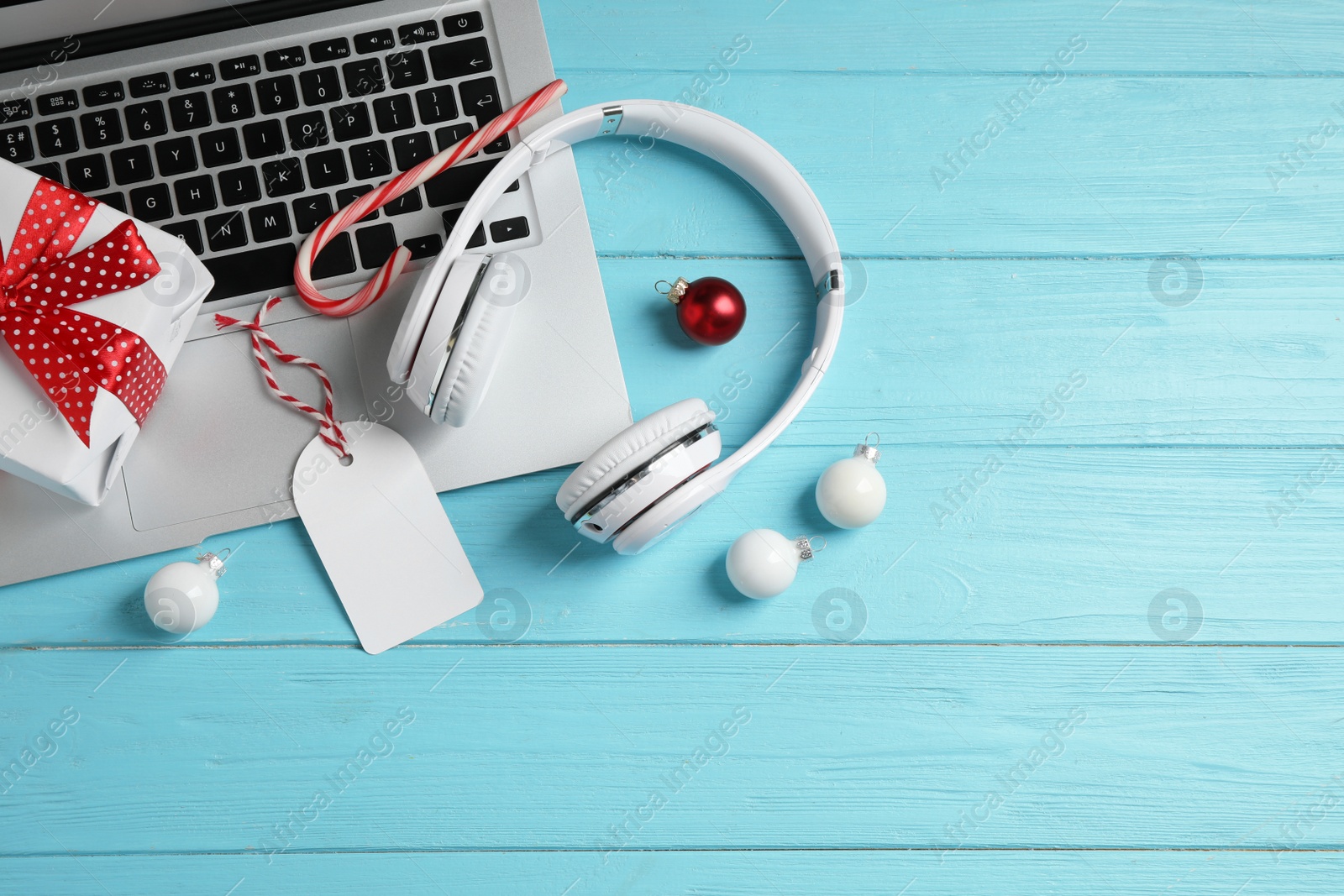 Photo of Flat lay composition with headphones on blue wooden background, space for text. Christmas music concept