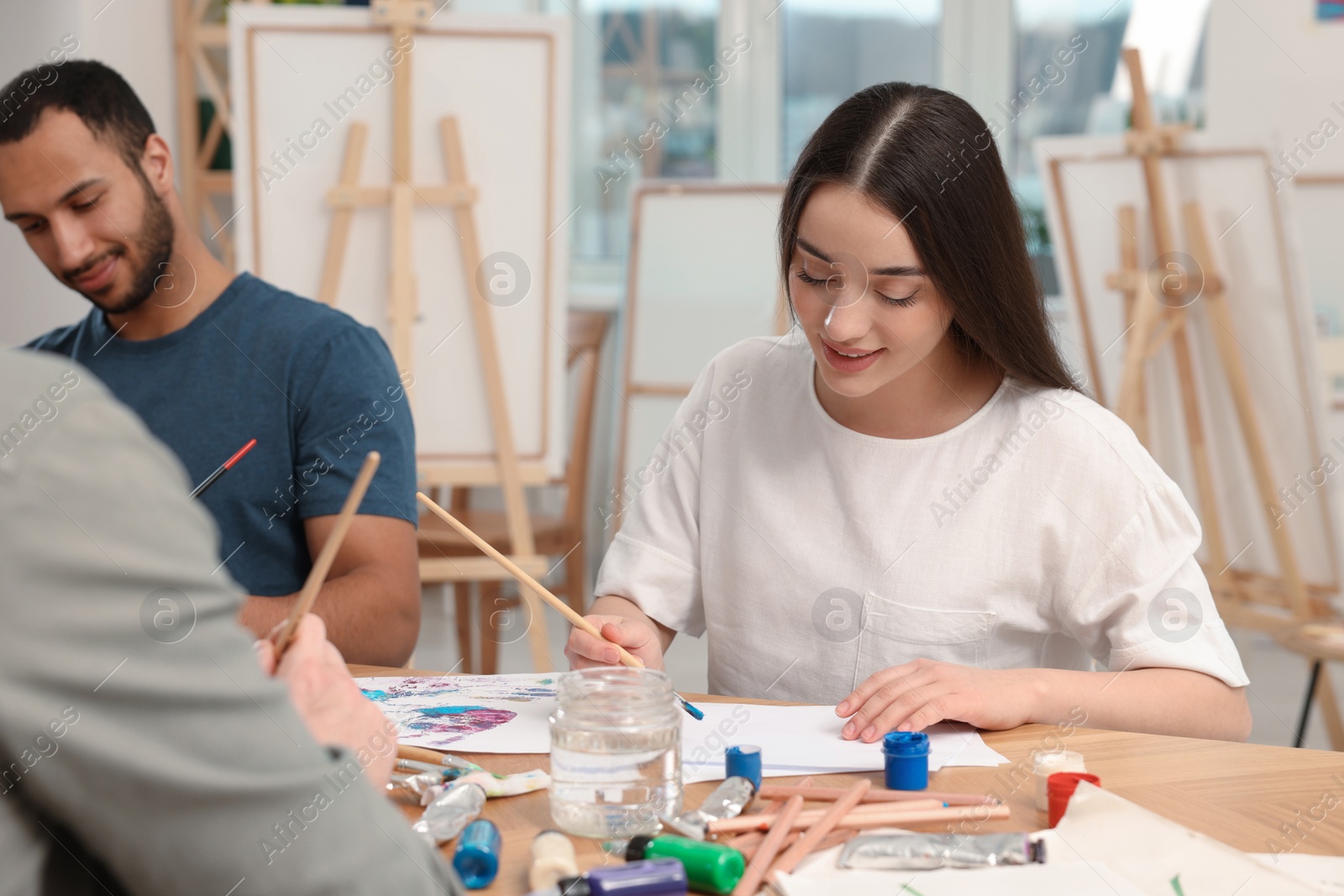 Photo of Group of students attending painting class in studio. Creative hobby