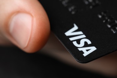 MYKOLAIV, UKRAINE - FEBRUARY 22, 2022: Woman holding Visa credit card, closeup