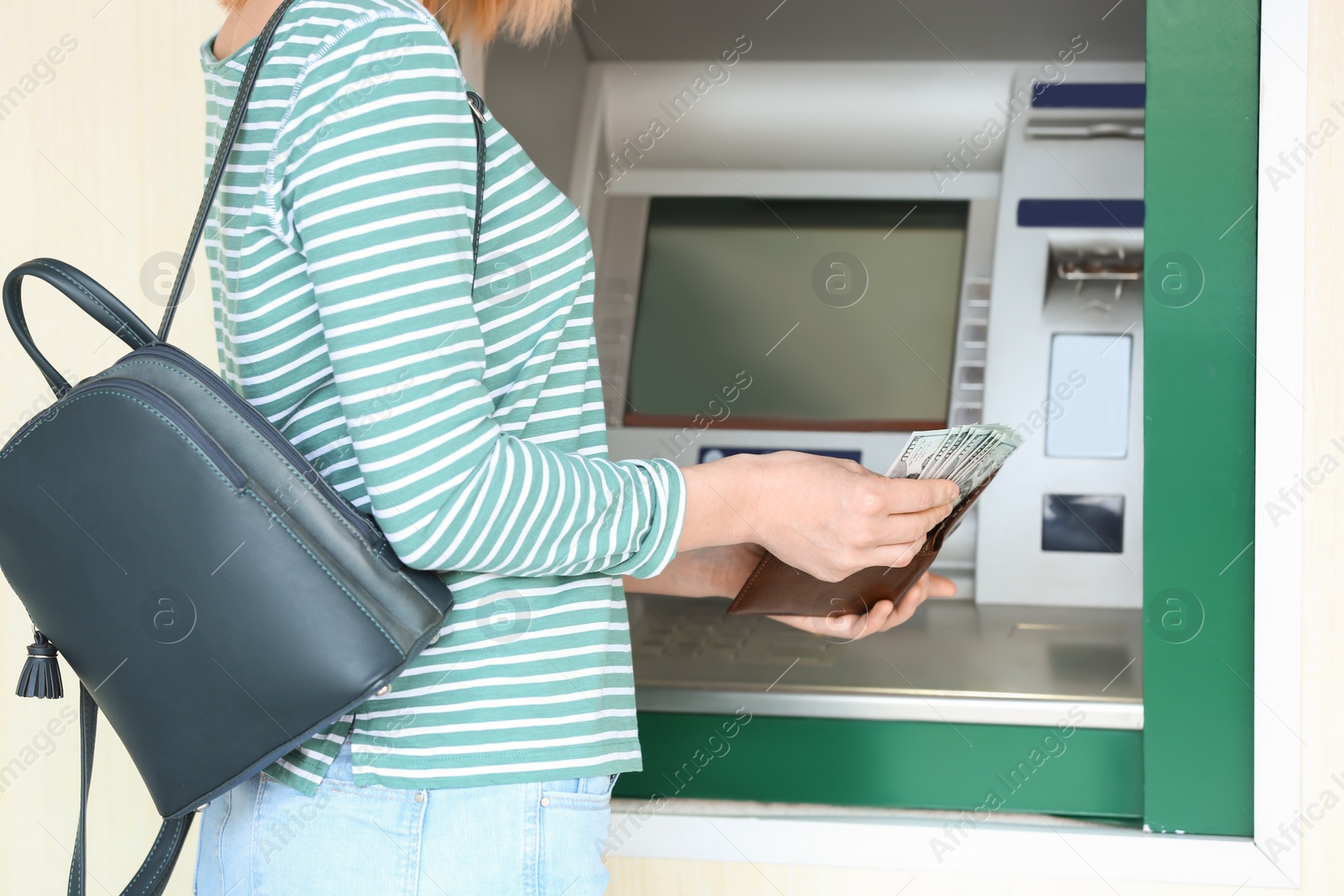 Photo of Woman with money near cash machine outdoors, closeup