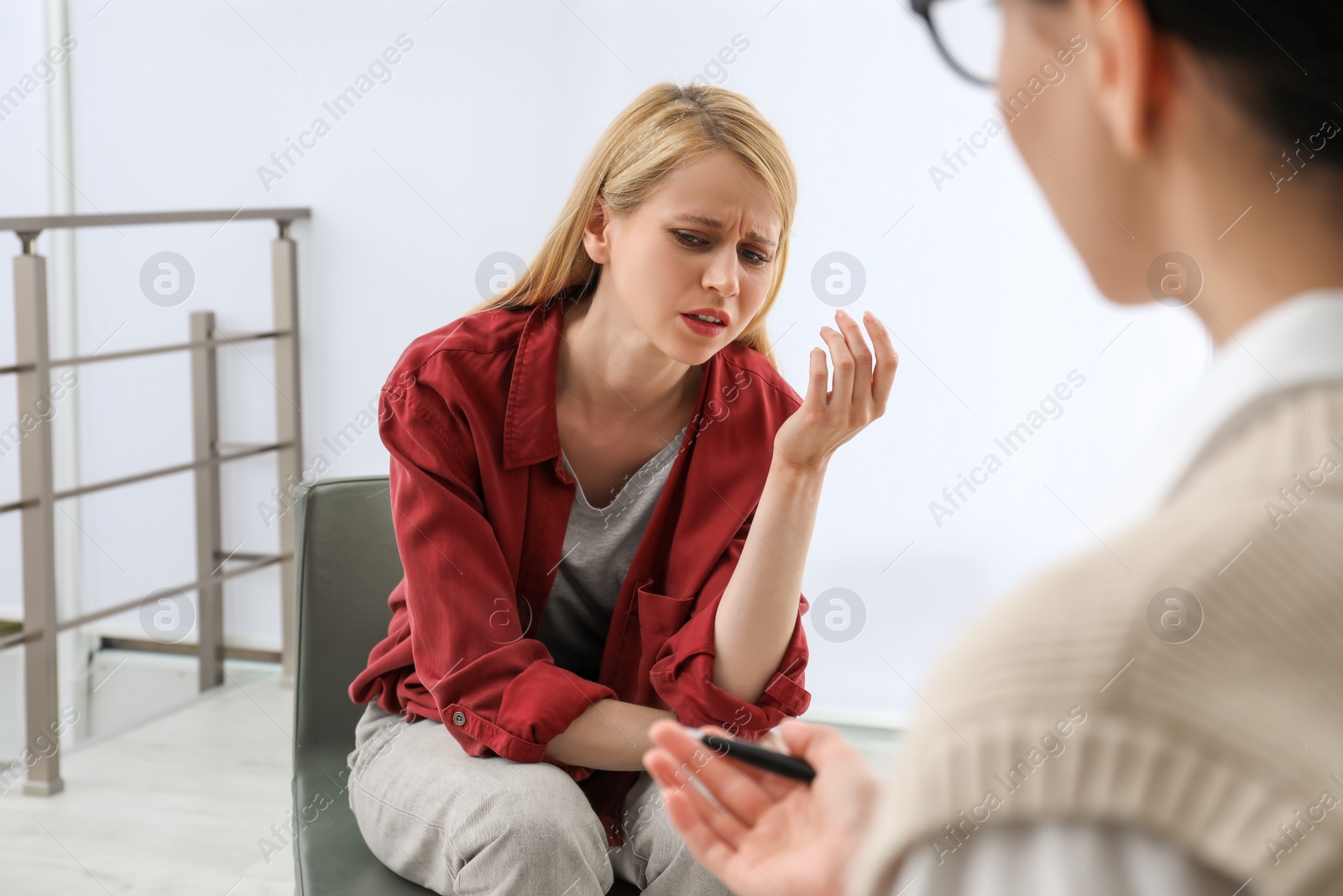 Photo of Psychotherapist working with drug addicted young woman indoors