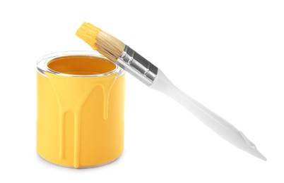 Photo of Can of yellow paint with brush on white background