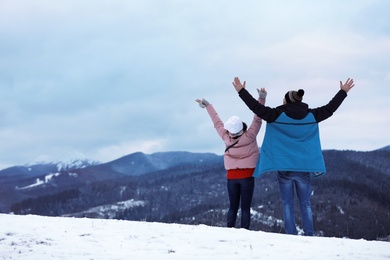 Photo of Couple enjoying mountain landscape, space for text. Winter vacation